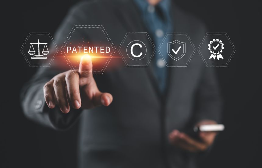 Patented patent copyright law business technology concept. businessman touch patented text with copyright icons for author rights and patented intellectual property.