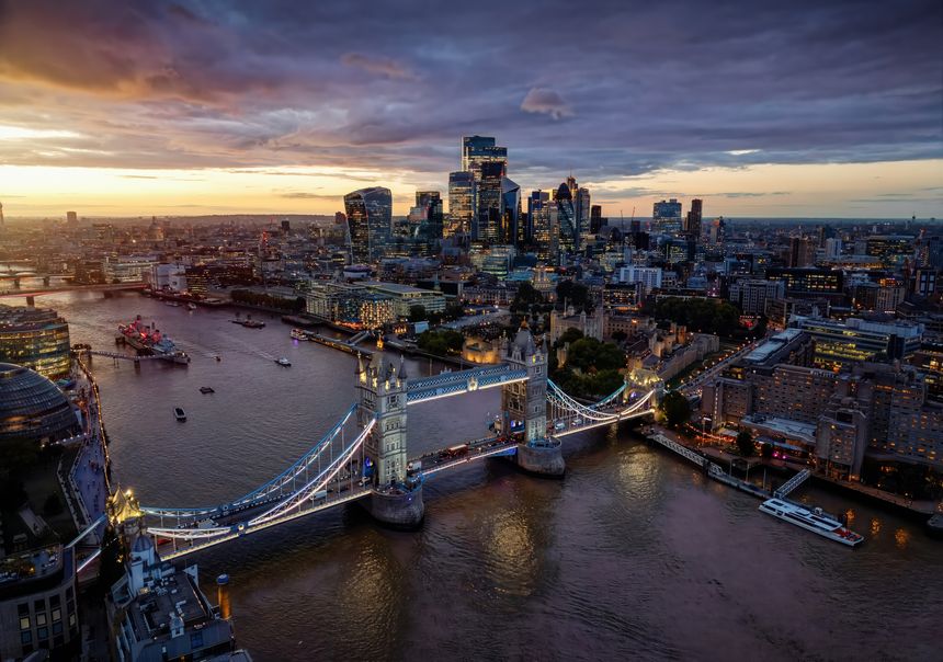 Beautiful, aerial evening view of the illuminated, urban skyline of London with Tower Bridge, River Thames and City skyscrapers