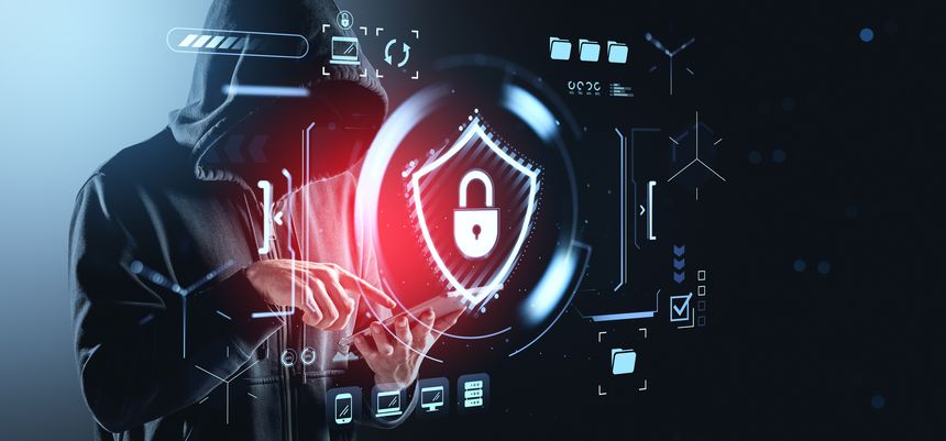 A person wearing a dark hooded sweatshirt, face obscured, is intensely focused on a tablet screen. Encircling them is a vibrant, glowing red digital shield with a prominent lock symbol, representing a secure system. The interface also shows abstract data streams, progress bars, and system icons, indicating a cyber threat scenario and the defense against it.