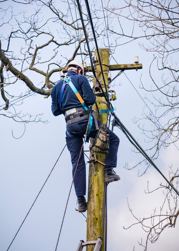 Conwy, UK - February 29, 2012. BT Openreach telecoms engineer repairing an overhead phone line. Technician working on a telegraph pole in Snowdonia, Wales.