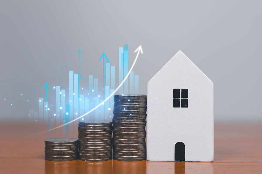 Stacks of coins beside a house model with rising digital charts, symbolizing property investment, financial growth, mortgage strategy, real estate market trends, and long-term wealth planning concepts