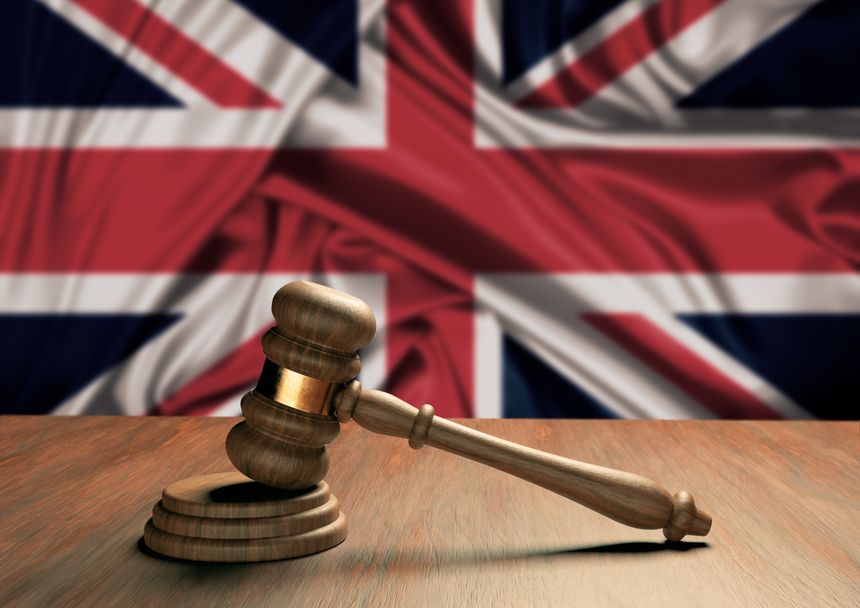 Wooden judge's gavel Symbol of law and justice with the flag of England. English Supreme Court. 3D Rendering