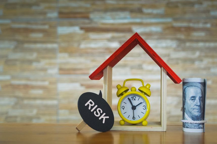 Wooden house, clock and wooden clip with text RISK