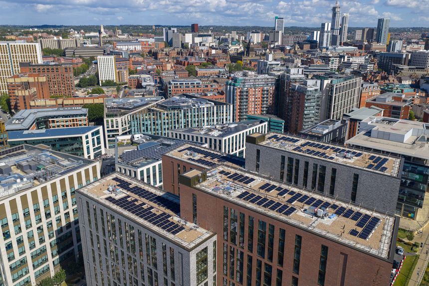 Aerial image of Leeds city centre showing rooftops with solar panels, modern high-rises, and the skyline in Yorkshire, England.