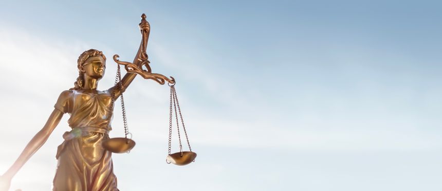Legal and law concept statue of Lady Justice with scales of justice and blue sky background
