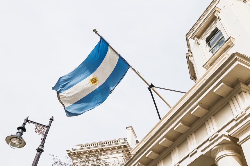Argentine flag waving outside the Embassy of Argentina in London with historic architecture. London, UK, 6 April 2024
