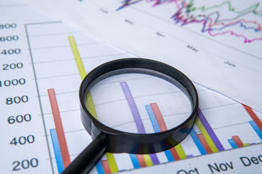 A close-up image of a magnifying glass and graph. Business analysis, due diligence concept.