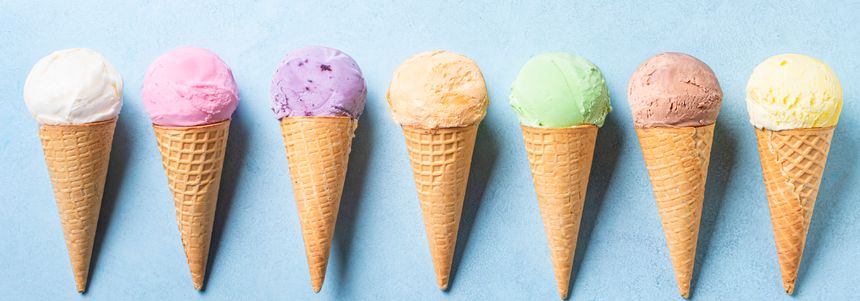 Various ice cream scoops in cones on blue background,  banner. Set of organic vegan colorful ice cream in waffle cones. Flat lay.