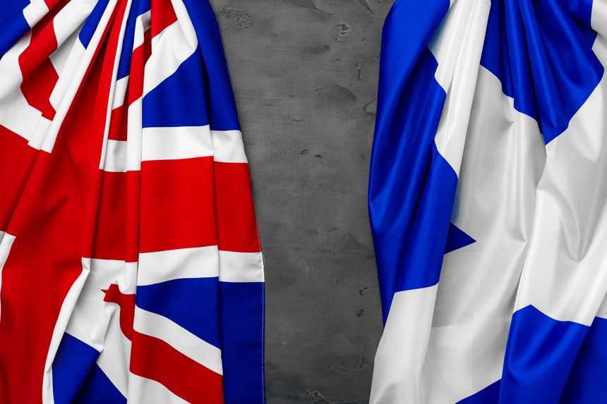 Flags of United Kingdom and Scotland on grey background top view