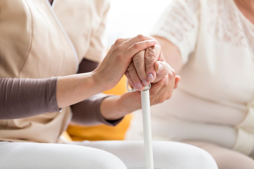 Woman comforting a senior lady, holding a cane