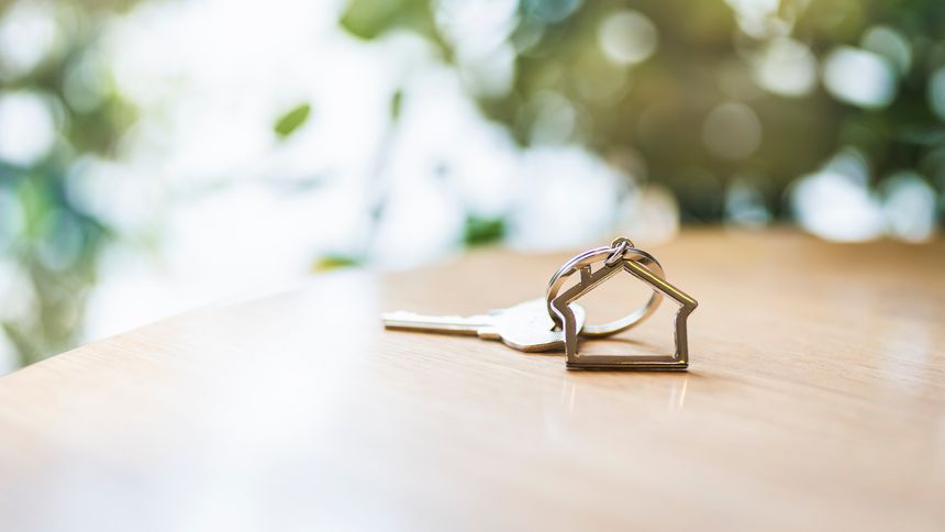 House model and key in home with light from window. Real estate agent offer house, property insurance and security, affordable housing concepts