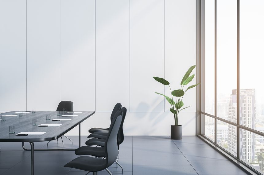 Modern conference room with a large table, chairs and a plant, with a city background through floor-to-ceiling windows, concept of a business meeting space. 3D Rendering