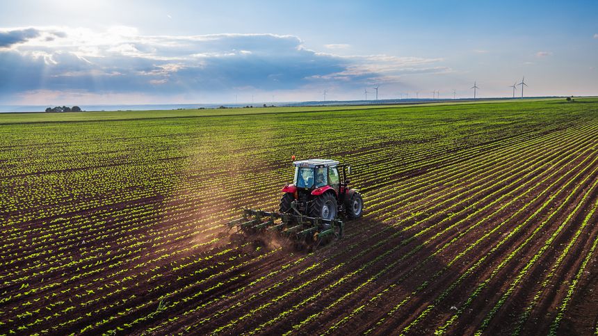 Tractor cultivating field at spring,aerial view