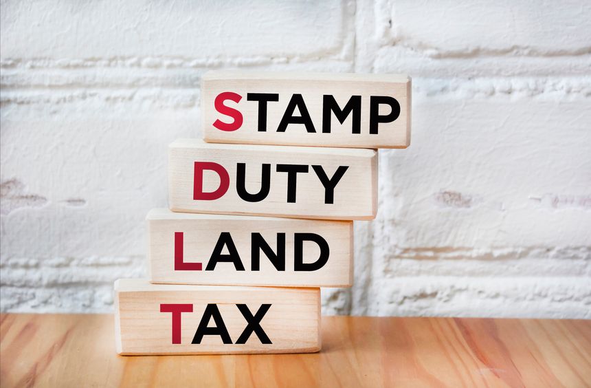SDLT - Stamp Duty, Land Tax written on blocks on an office desk.