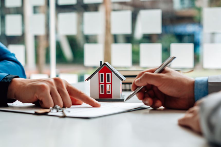 Customers interested in buying a home sign a signature to enter into a home purchase contract with a real estate agent. Mortgage loan approval home loan and insurance concept.