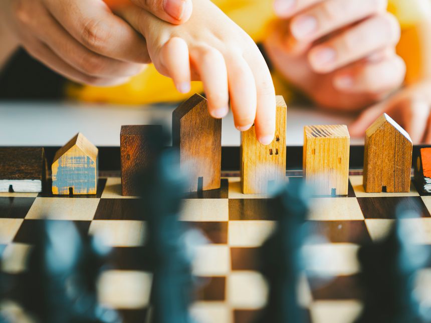Baby Hands holding a house model with mother hand. The concept of relocation, mortgage, inheritance, family assurance protection and legacy planning.
