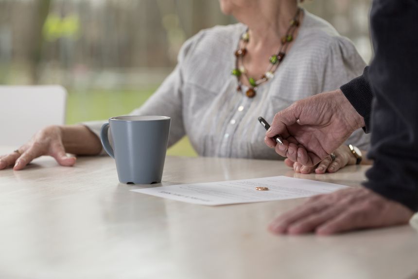 Close-up of elder man signing divorce documents