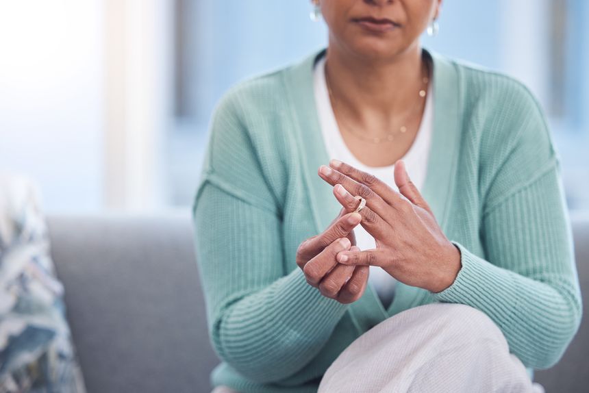 Doubt, stress and hands taking off ring for a divorce after marriage conflict, toxic relationship or cheating. Anxiety, mental health or sad senior woman removing her engagement ring after fighting