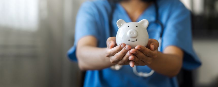 Nurse or doctor with stethoscope holding piggy bank in hand. Concept of medical expenses, finance, saving money, health insurance, medicine, donation and pension. Healthcare service cost.