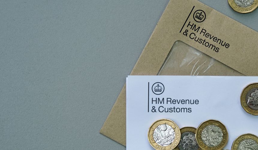 Billericay, Essex, United Kingdom, April 9, 2026. Letter with brown envelope with HM Revenue and Customs logo. Scattered one pound coins. Illustrates Government demand to pay tax. Studio shot. Copy space