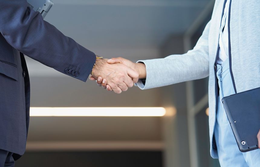 Two business professionals shaking hands, establishing a partnership and showing collaboration