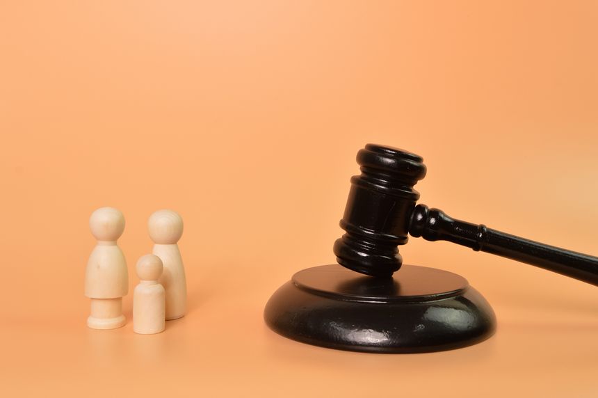 Family doll figures standing with judge gavel. Family law concept
