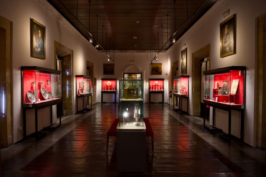 Museum exhibition hall with illuminated display cases showcasing religious artifacts and sacred art in cathedral treasury Oviedo Asturias Spain. Photo taken on September 9 2025. Editorial use only.