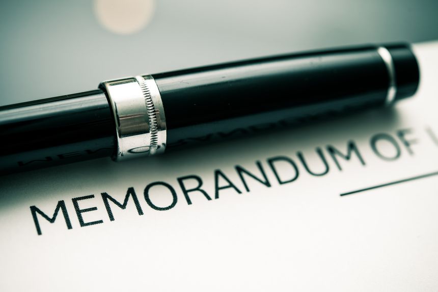 A black pen poised above a memorandum, showcasing important agreements, effective communication, and professional documentation. Ideal for business, contracts, and formal correspondence imagery.