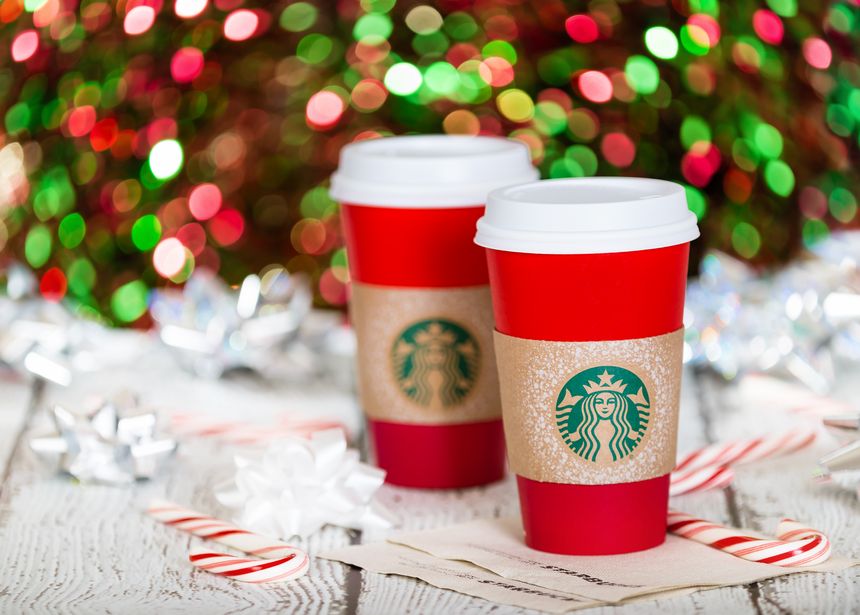 Dallas, TX, USA - November 19, 2015: A cup of Starbucks popular holiday beverage, served in the new 2015 designed red holiday cup. Displayed with candy canes against sparkly holiday background.