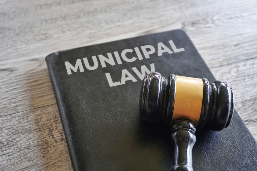 A black book titled MUNICIPAL LAW with a wooden gavel. Justice and law concept.