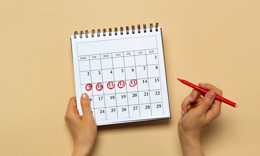 The concept of the menstrual cycle, period. The woman marks the days on the calendar.