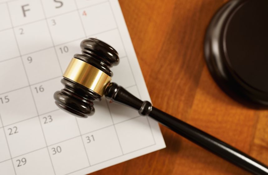 Law, legislation, justice and time concept with a close up top view of a judge gavel on a calendar page. Statute of limitations and prescriptive periods deadline in legal proceedings conceptual images.