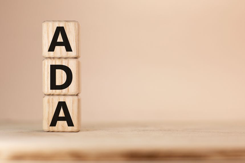 Word ADA on wooden blocks beige background top view