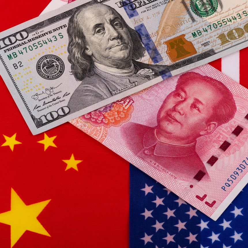 Banknotes in denominations of 100 US dollars and 100 Chinese yuan against the background of the American flag and the flag of China