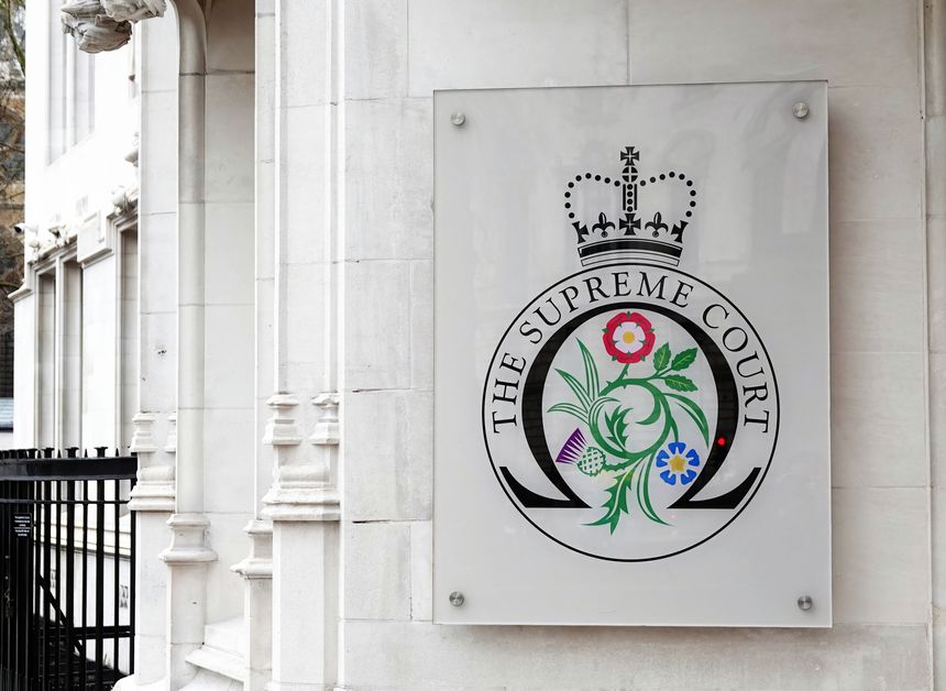 London, UK - March 15, 2023: The entrance to the Supreme Court with a sign displaying the official Supreme Court badge in Westminster, London, UK.