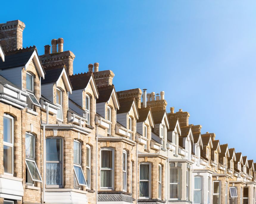 Row of terraced town houses typical of urban street areas on sunny summer day. Real estate investment opportunity in realty property market. Features Victorian style architecture and dormers.