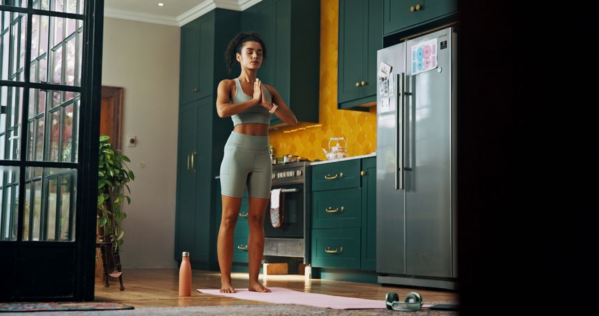 Meditation, wellness and yoga with woman in kitchen of home for balance, health or holistic routine. Chakra, fitness and stress relief with yogi person in apartment for exercise or inner peace