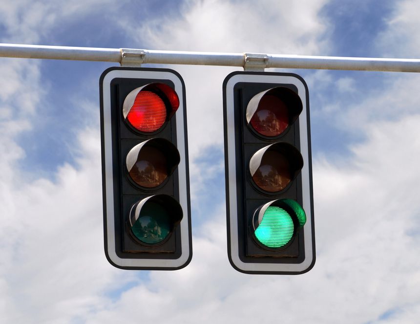 Red and green traffic lights against blue sky backgrounds