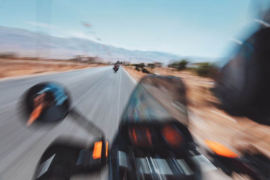 Highway ride on a deserted landscape. Motorbike in a fast blur motion. Biker on an adventure tour. Extreme sports.