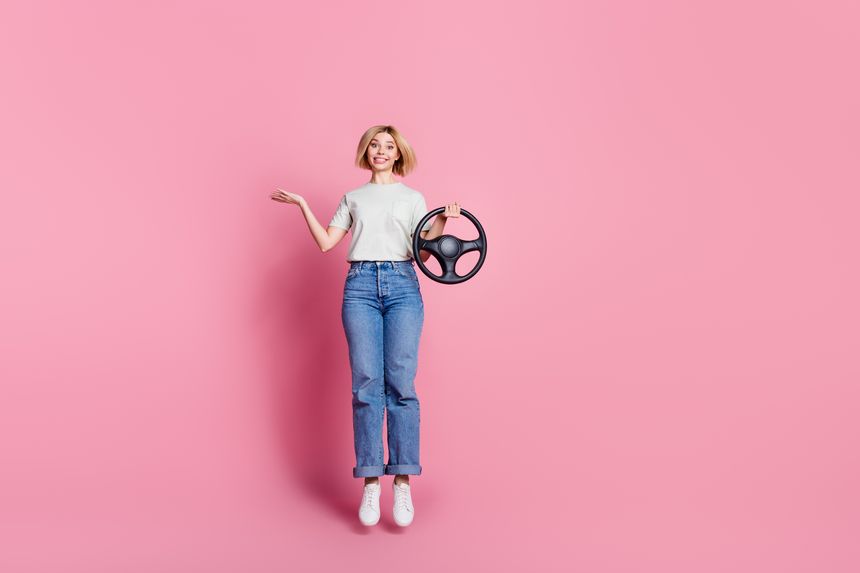 Photo of funny lovely confused girl wear trendy grey clothes hold steering wheel isolated on pink color background.