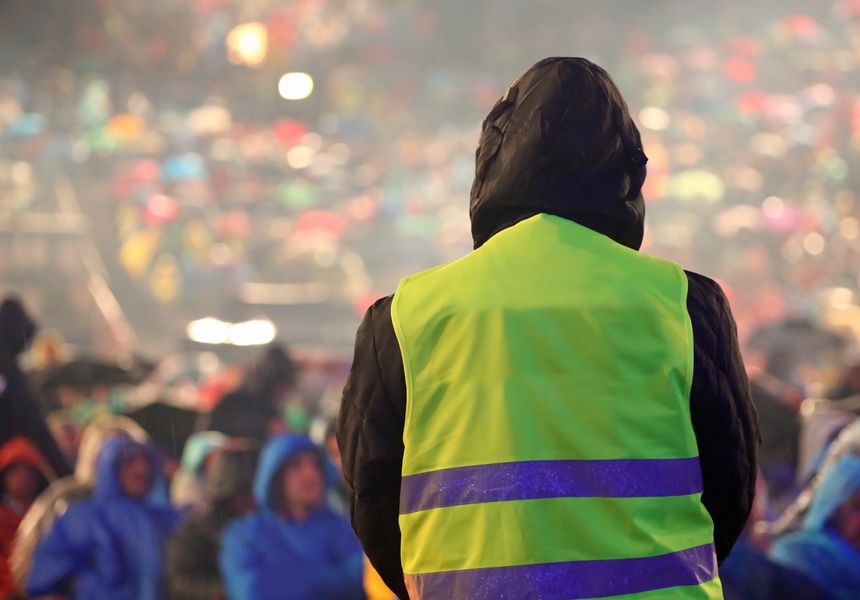 security guard with yellow jacket when it is raining during the live concert