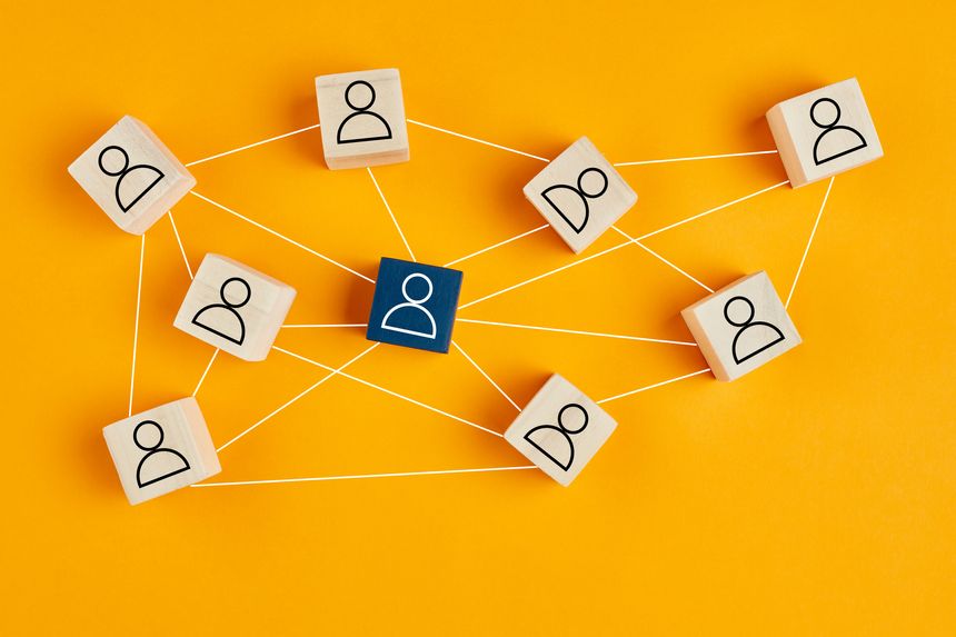 Wooden blocks with people icon on yellow background. Organization structure, social network, leadership, team building, job recruitment, management or human resources concepts.