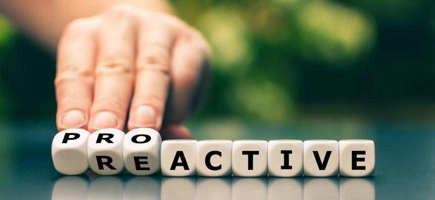 Hand turns dice and changes the word reactive to proactive.