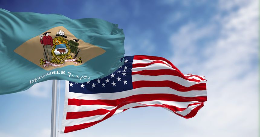 Delaware state flag waving with the national american flag. Yellowish-beige rhombus shape with the state coat of arms on a pale blue background. 3d illustration render. Selective focus