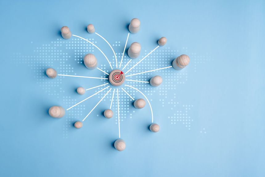 Wooden block with target icon linked with wooden peg dolls connect link for customers focus group, development resource achievement to target, customer relationship management concept