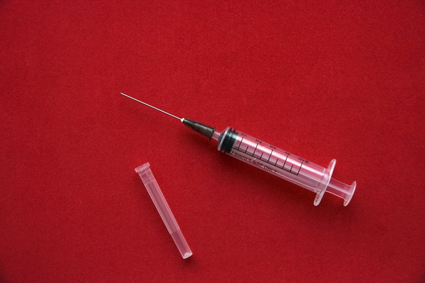 Medical syringe on a red background