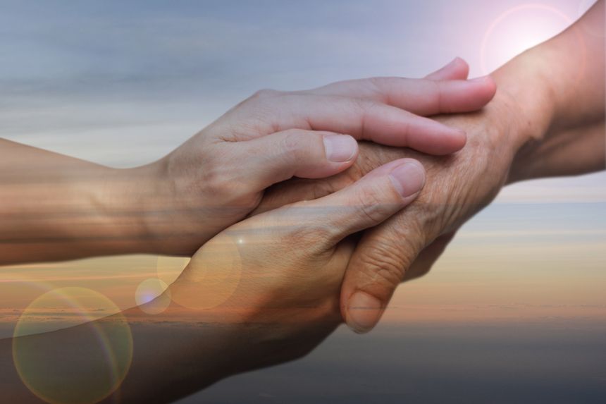 Caregiver, carer hand holding elder hand in hospice care with sky sunset background. Euthanasia  Philanthropy kindness to disabled concept.