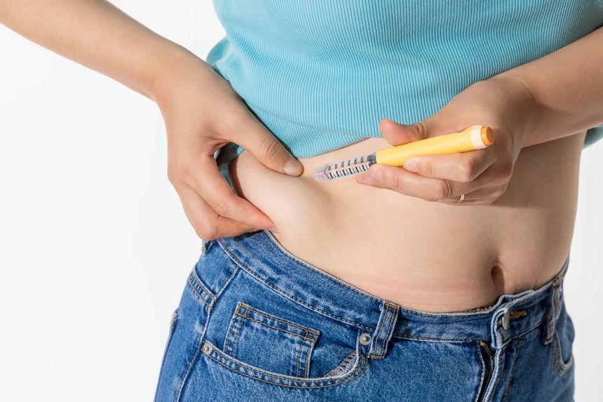 A woman injecting herself with obesity medication