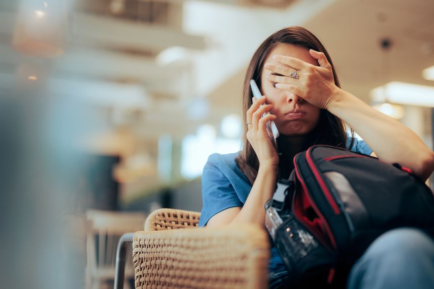 Stressed traveler speaking on her cellphone feeling overwhelmed