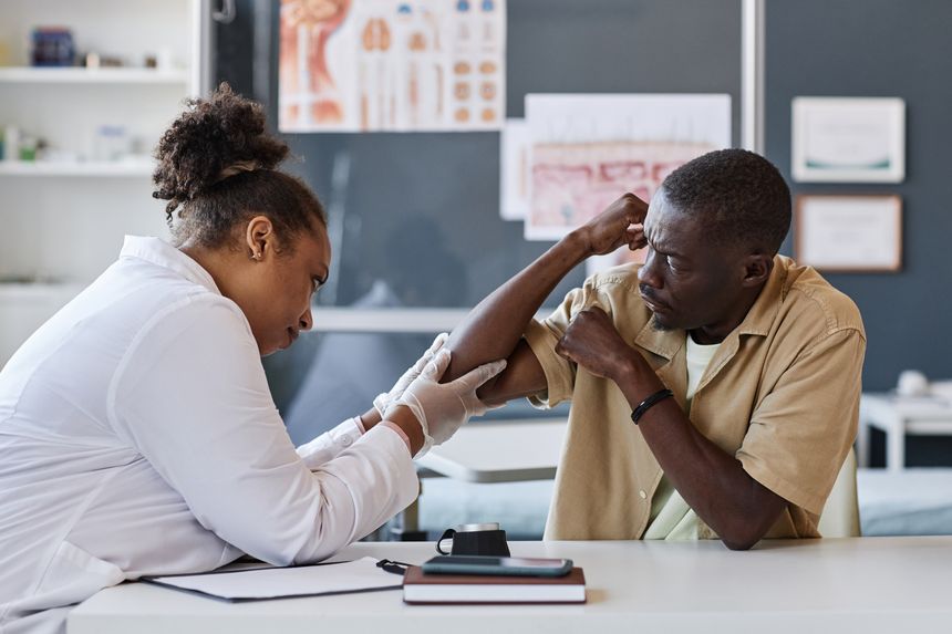 Side view portrait of female dermatologist examining African American patient complaining of skin rash in clinic